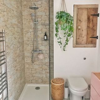 walk in shower with stone tiled wall