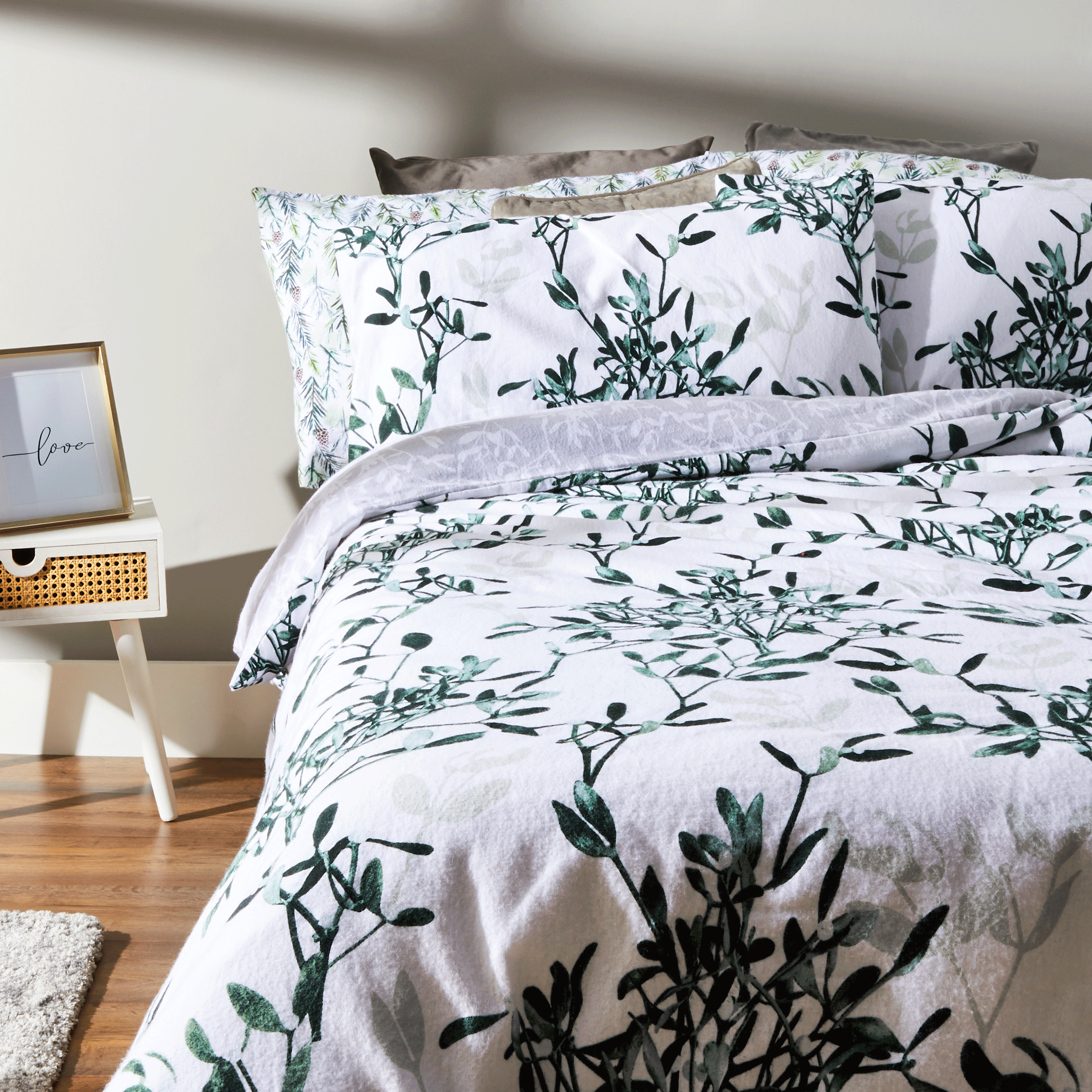 bedroom with white wall bed with white designed bedding and wooden flooring