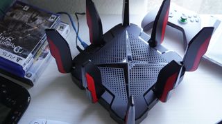 TP-Link Archer GX90 gaming router from above near video games