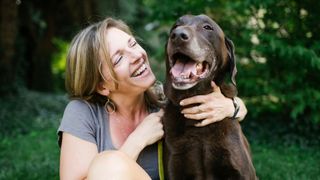Easy ways to teach your dog new tricks — woman cuddling brown dog