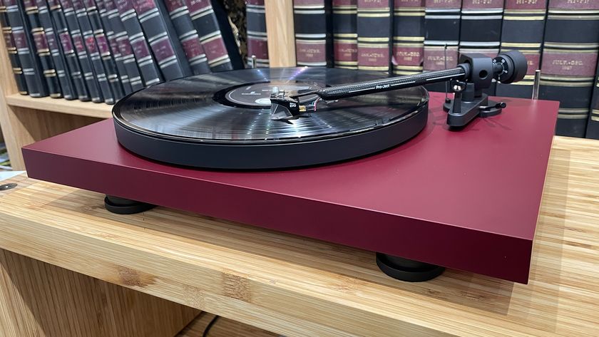 Pro-Ject Debut Evo 2 turntable on wooden hi-fi rack in front of bookcase