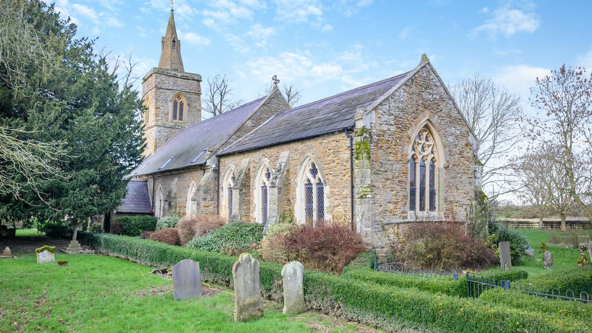 The exterior of a converted church with its own graveyard