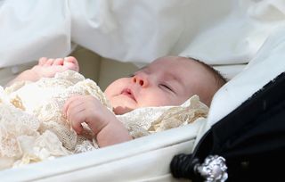 Princess Charlotte -Princess Charlotte of Cambridge in her pram, leaves her Christening at St. Mary Magdalene Church in Sandringham, England, on July 5, 2015. Britain's baby Princess Charlotte was christened on Sunday in her second public outing since her birth nine weeks ago to proud parents Prince William and his wife Kate. The low-key ceremony took place in a church on the country estate of great grandmother Queen Elizabeth II. AFP PHOTO / POOL / CHRIS JACKSON (Photo by Chris Jackson / POOL / AFP) (Photo by CHRIS JACKSON/POOL/AFP via Getty Images)
