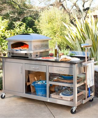 making pizza on an outdoor pizza oven