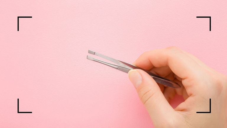 Tweezers on a pink backdrop to pluck hairs you shouldn't pluck