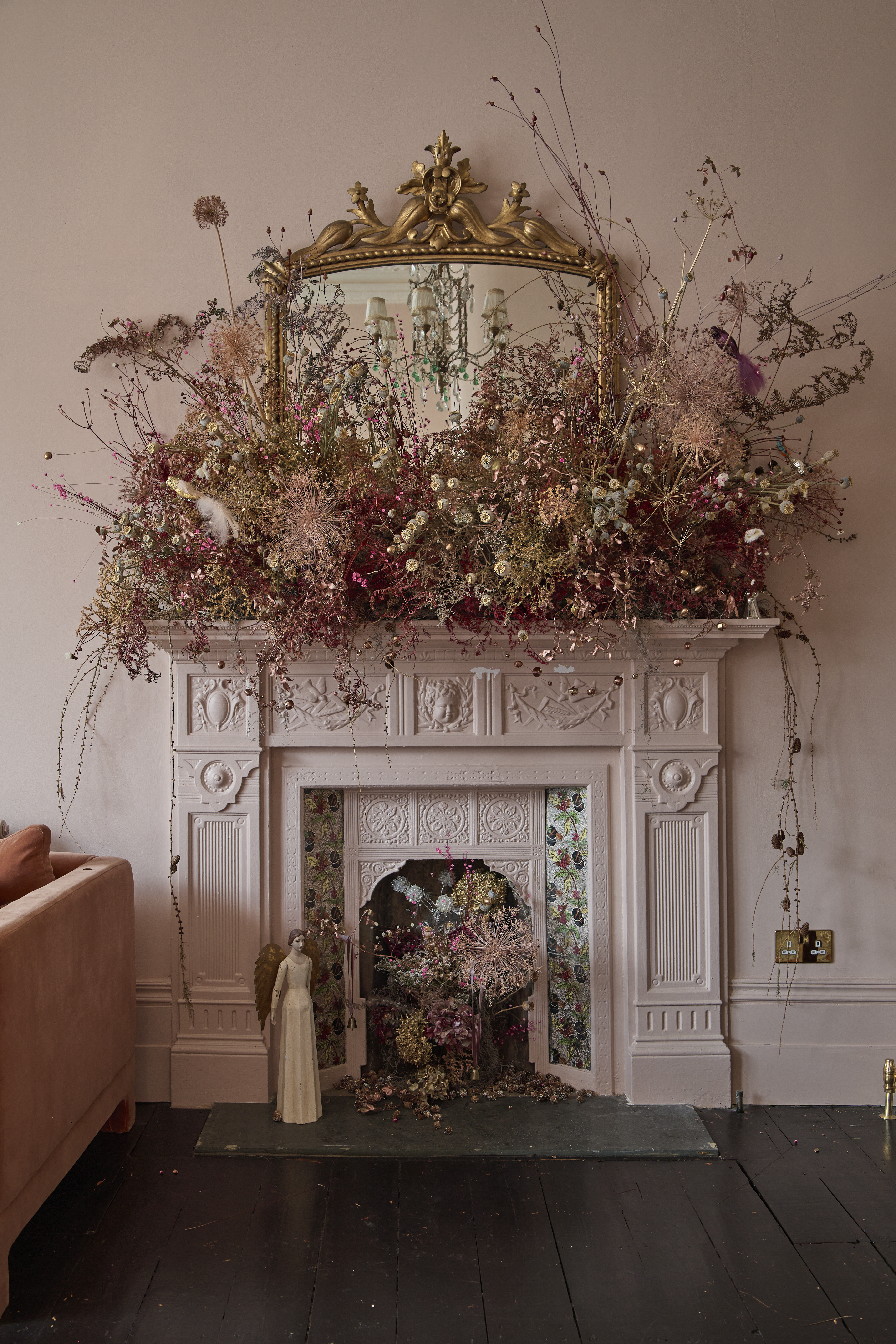 Dried flowers display on traditional fireplace with gold mirror behind