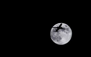 Photographer Sid Vedula captured this amazing view of the full moon of Aug. 1, 2012, with a passing airplane in silhouette. 