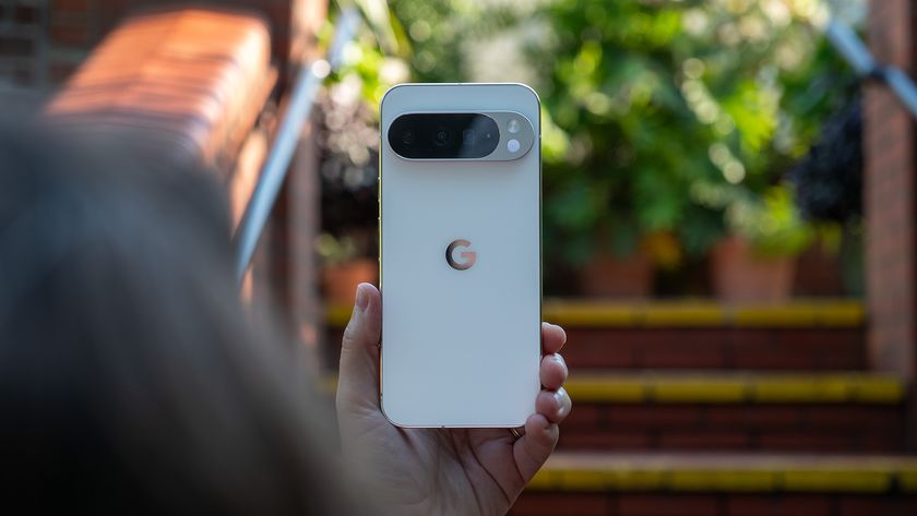 Holding a white Google Pixel 10 Pro XL in front of red brick stairs