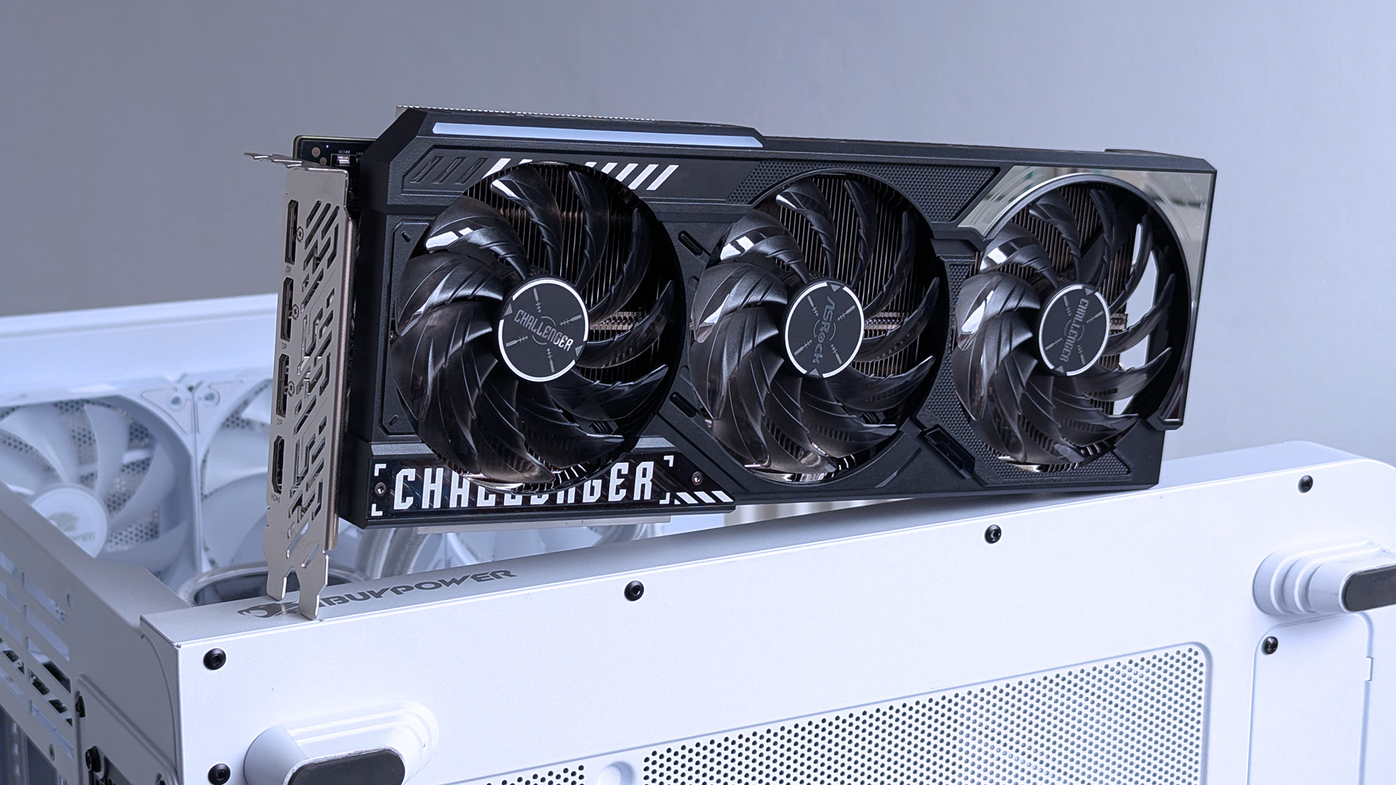ASRock Challenger Radeon RX 9070 XT GPU with three large fans, labeled "Challenger," is mounted on a white computer case backdrop.