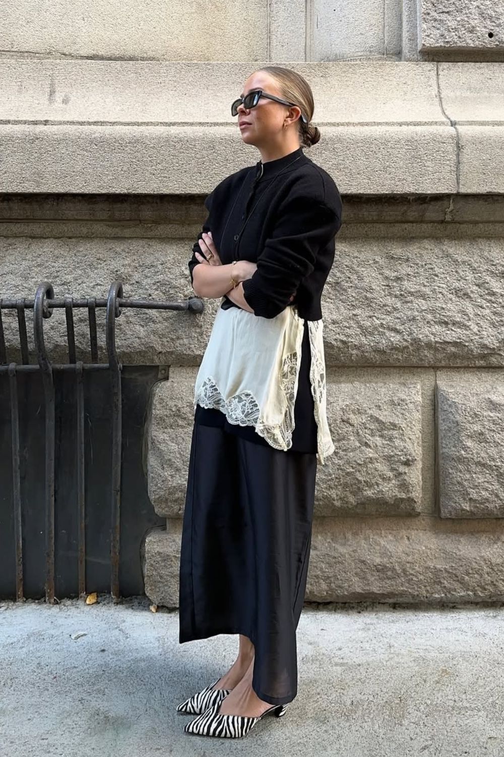 Anti-flat shoes trends winter 2025 @dinahansen wearing a black cardigan, slip dress, black skirt and zebra print heeled mules