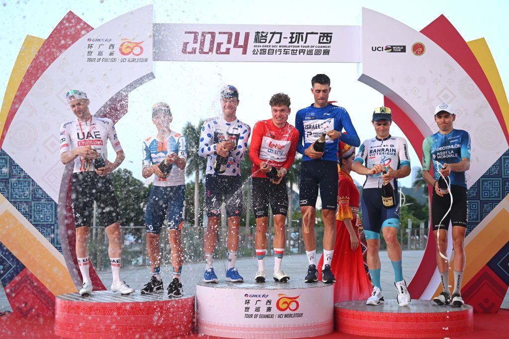 NANNING CHINA OCTOBER 20 LR Tim Wellens of Belgium and UAE Team most combative rider prize winner Oscar Onley of The United Kingdom and Team dsmfirmenich PostNL on second place Pepijn Reinderink of The Netherlands and Team Soudal QuickStep Polka Dot Mountain Jersey Lennert Van Eetvelt of Belgium and Team Lotto Dstny Red Leader Jersey Ethan Vernon of The United Kingdom and Team Israel Premier Tech Blue Points Jersey stage winner Matevz Govekar of Slovenia and Team Bahrain Victorious and Alex Baudin of France and Decathlon AG2R La Mondiale Team on third place pose and celebrate on the podium ceremony after the 5th GreeTour of Guangxi 2024 Stage 6 a 134km stage from Nanning to Nanning UCIWT on October 20 2024 in Nanning China Photo by Dario BelingheriGetty Images