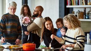 Multi-generational family cooking dinner together at home