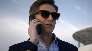 Topher Grace wearing sunglasses and talking on the phone in The Waterfront