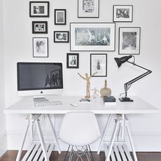computer on desk with chair and wall frames
