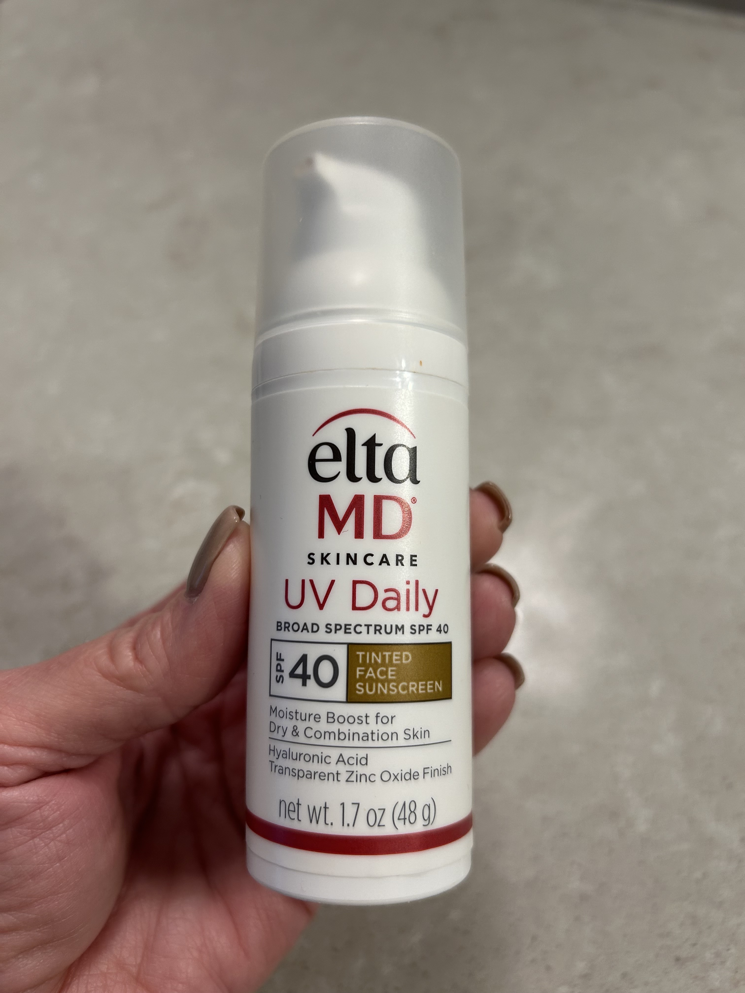 An image of Lori Brascia holding the Elta MD UV Daily Tinted Face Sunscreen SPF 40.