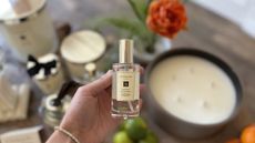 Jo Malone Mini Room Spray being held in my hand over a table of Jo Malone products