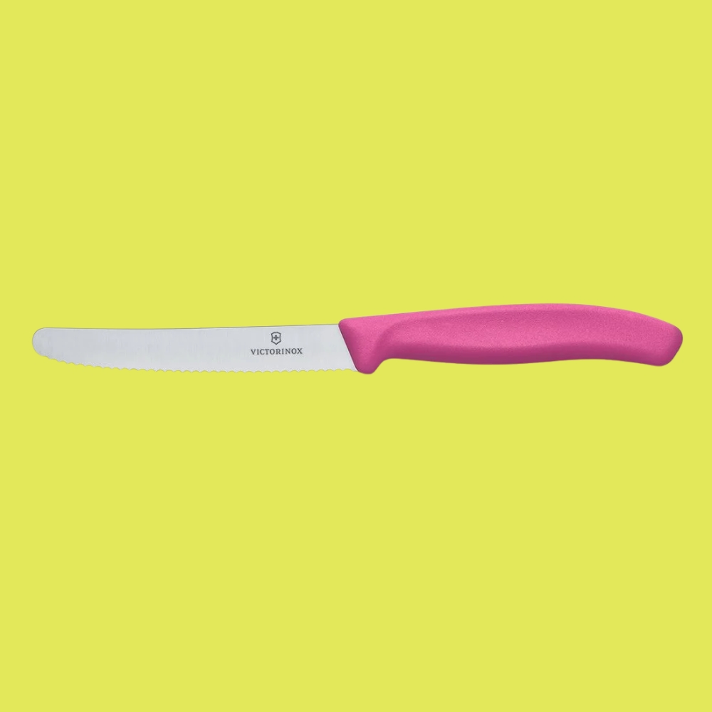 Victorinox Serrated Vegetable Knife 10cm in pink against a yellow background.