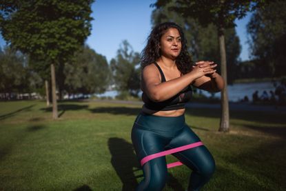 Mixed-race woman with elastic band doing sport in city, Proworks Glute Band