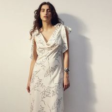 model wears white satin dress with tie sleeves