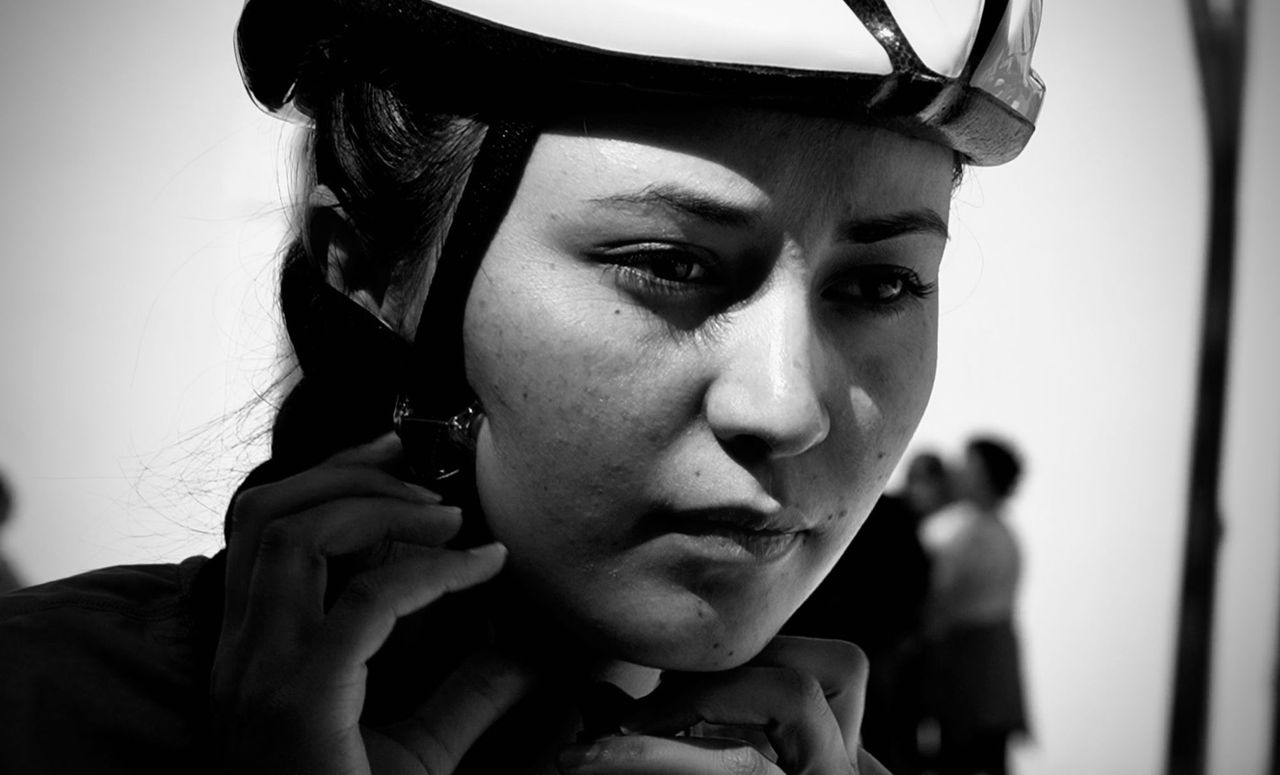 Female cyclist clips up her helmet