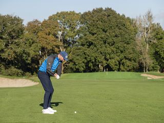 Adam Harnett hitting a shot to the green from the fairway at West Surrey Golf Club