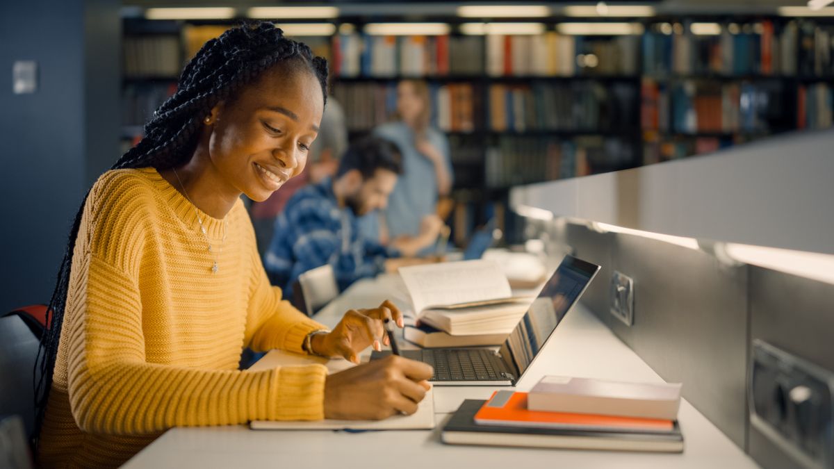 Student uses Laptop, Writes Notes for the Paper