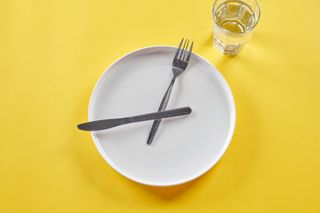A plate with a knife and fork representing the hands of a clock