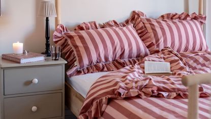 a bed with pink and red striped ruffled 