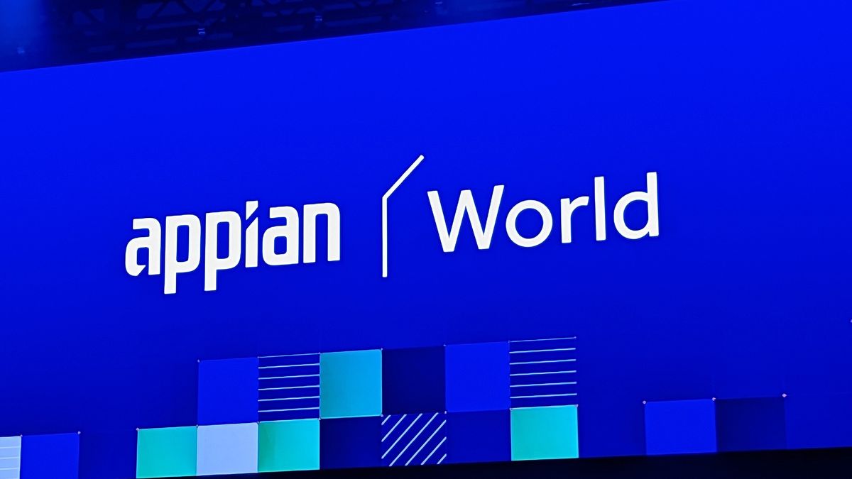 The Appian logo (stylised text reading &#039;appian&#039;) next to the word &#039;World&#039; in white on a large blue led screen, shot from a distance on a conference stage