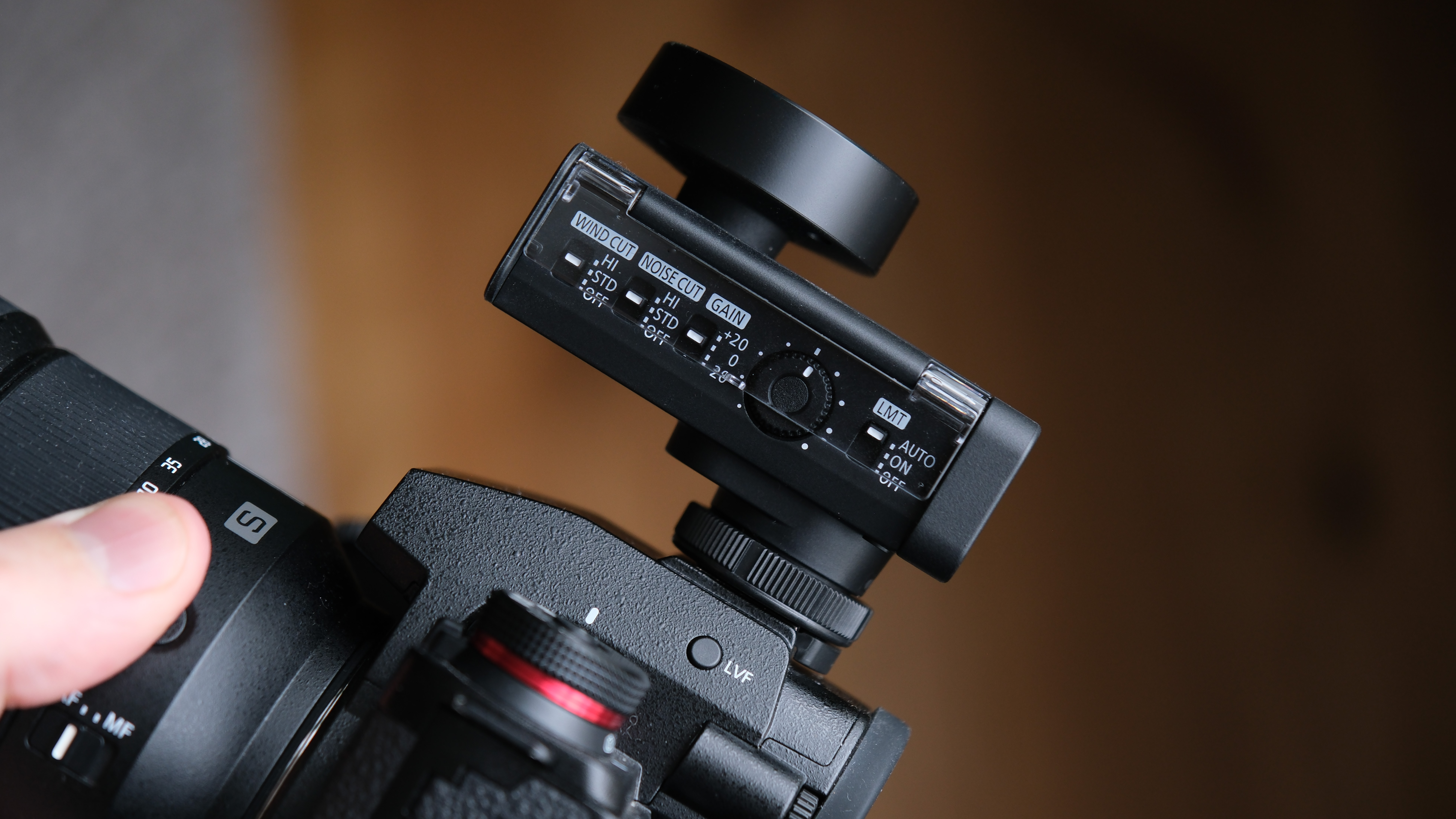 Side view of the Panasonic Lumix DMW-DMS1 microphone with its hinged cover open, revealing wind cut, noise cut, gain and limiter controls.