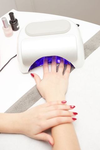 closeup of a uv lamp with a female hand inside