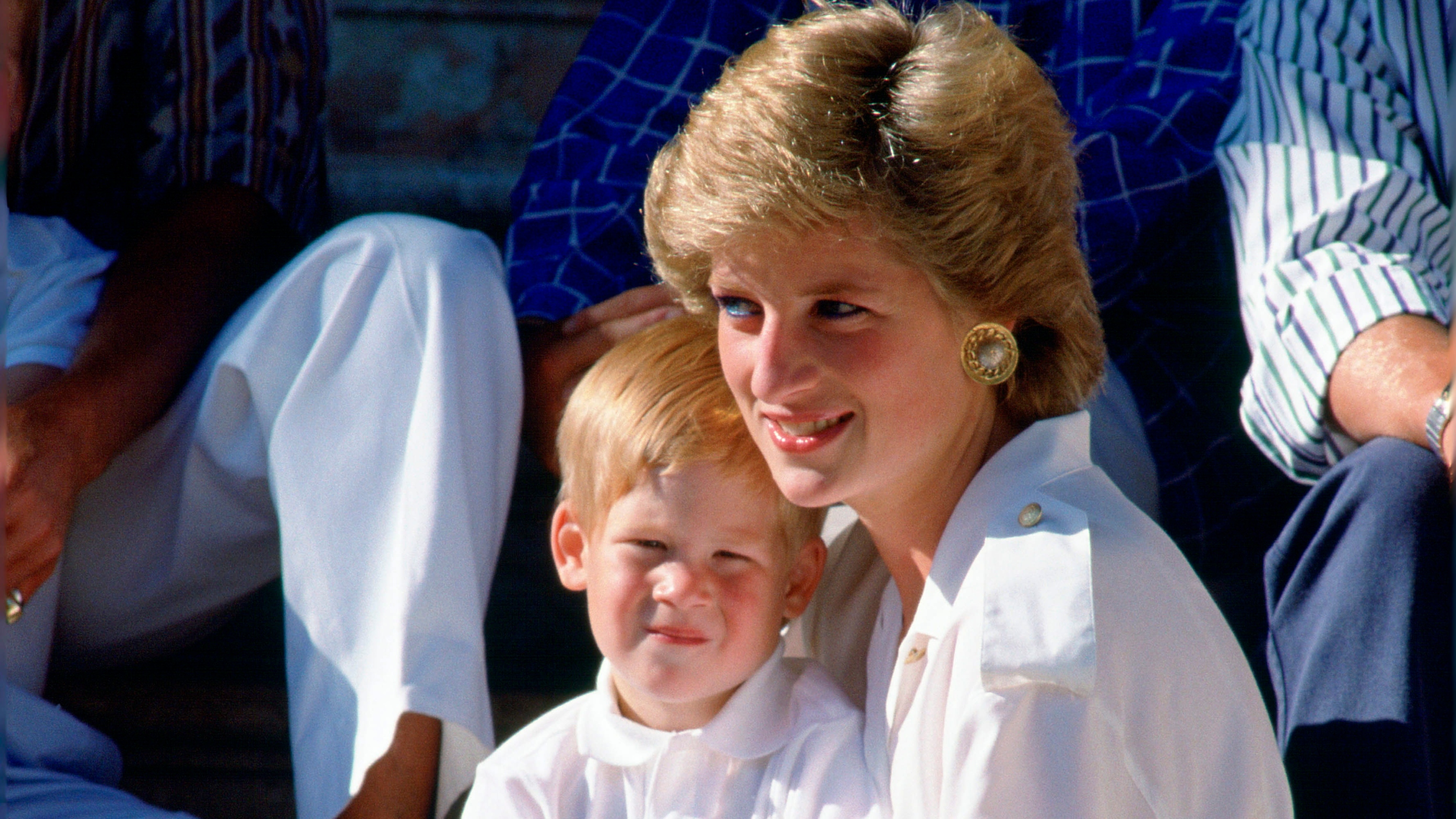 Diana, Princess of Wales, sitting on the steps of the Marivent Palace with Prince Harry at a photocall