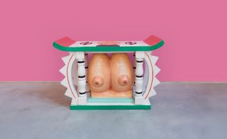 carved colourful stool with breasts set inside