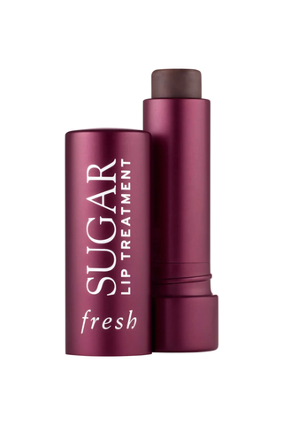 An open tube and lid for fresh Sugar Lip Treatment set against a white background.