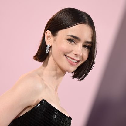 Lily Collins wearing a custom black Armani Priv&eacute; gown to the 'Emily in Paris' Los Angeles premiere August 2024