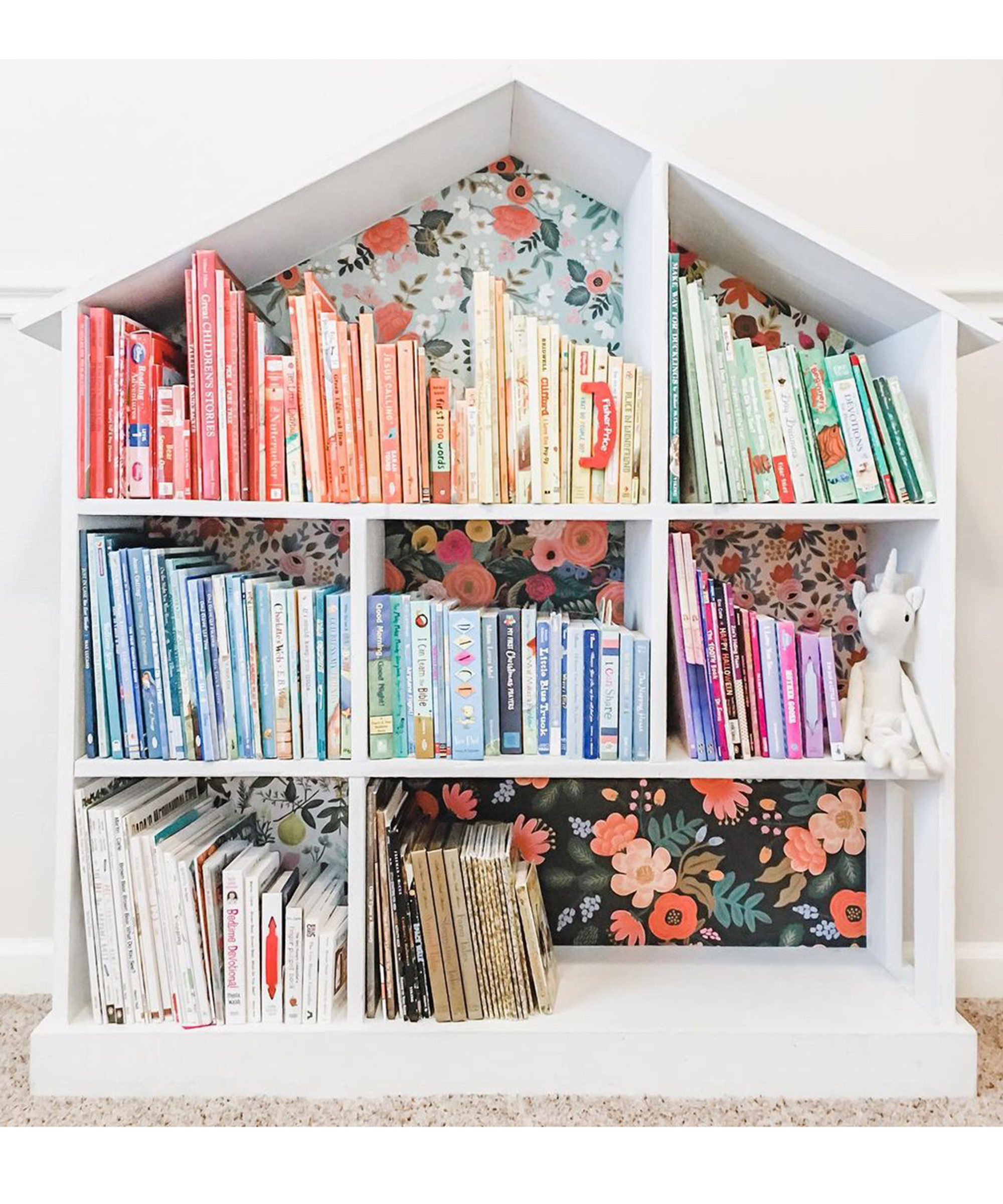 A white dollshouse repurposed into DIY bookshelf