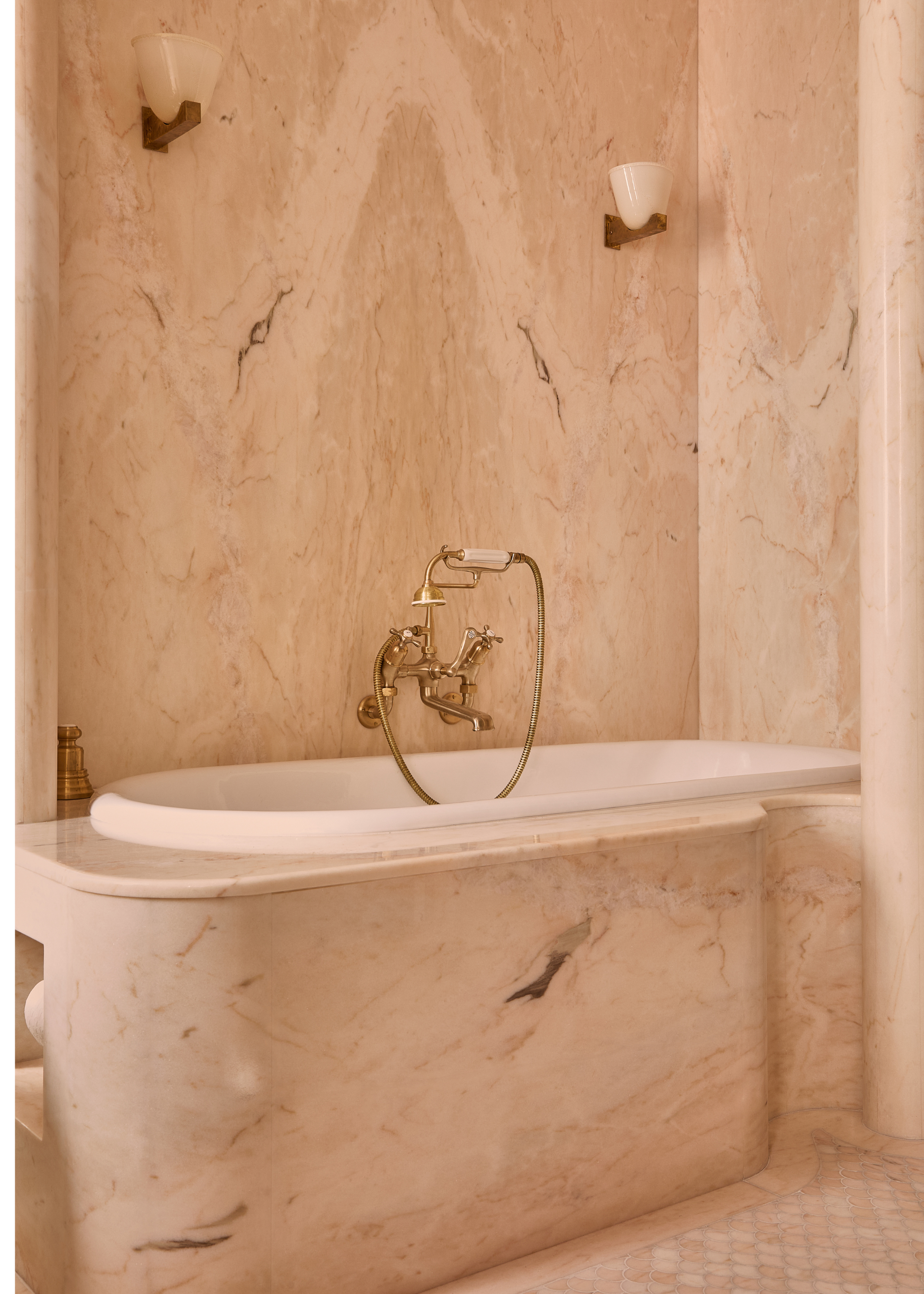 pink marble bathroom with a wrap around bathtub