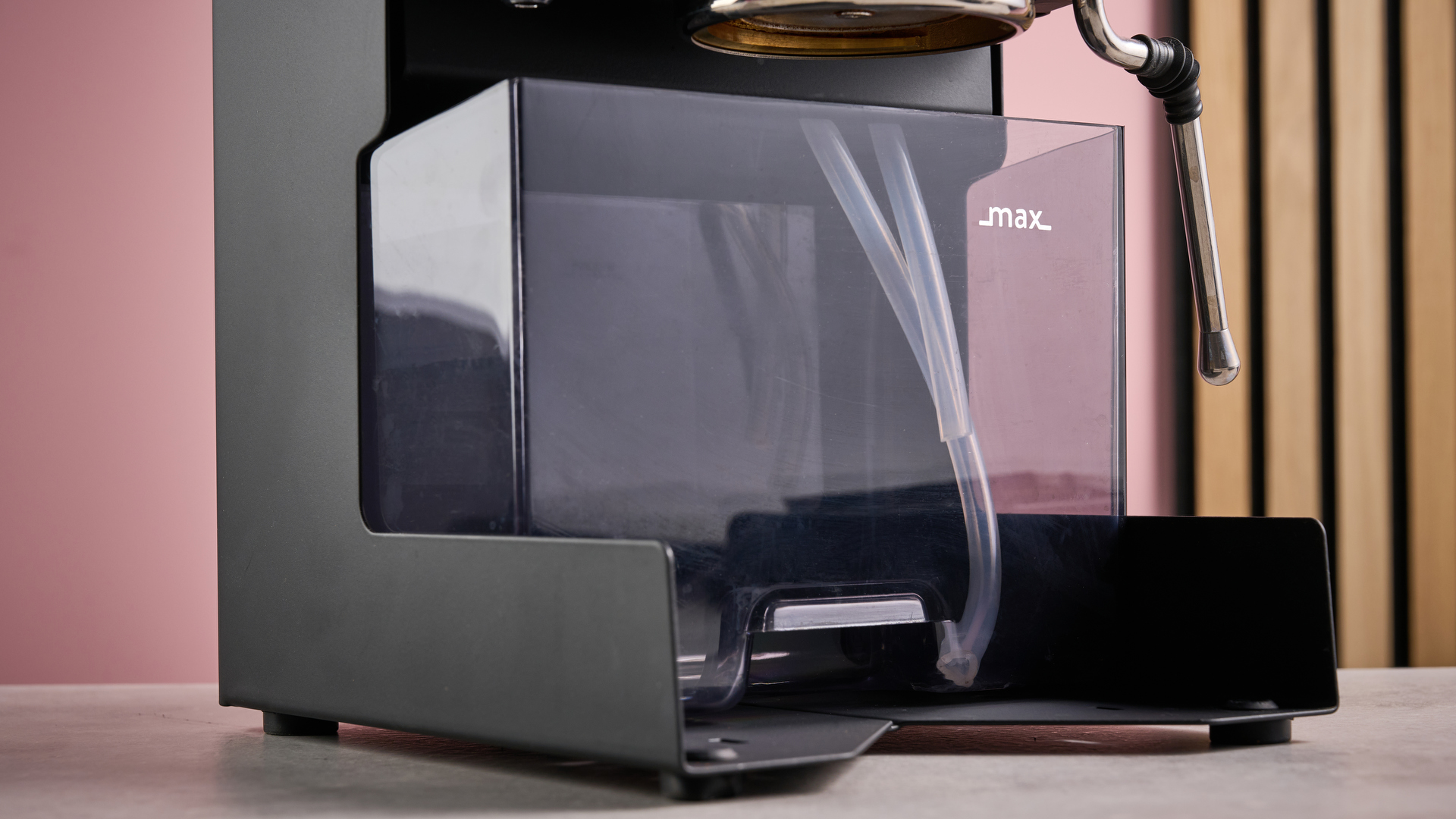 A closeup of the Gaggia Classic E24 Evo Pro&#039;s empty water tank, with two lenghts of plastic hosing clearly visible