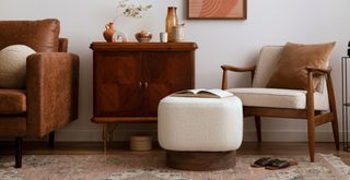 vintage living room with brown leather sofa and retro wood frame armchair with boucle accessories