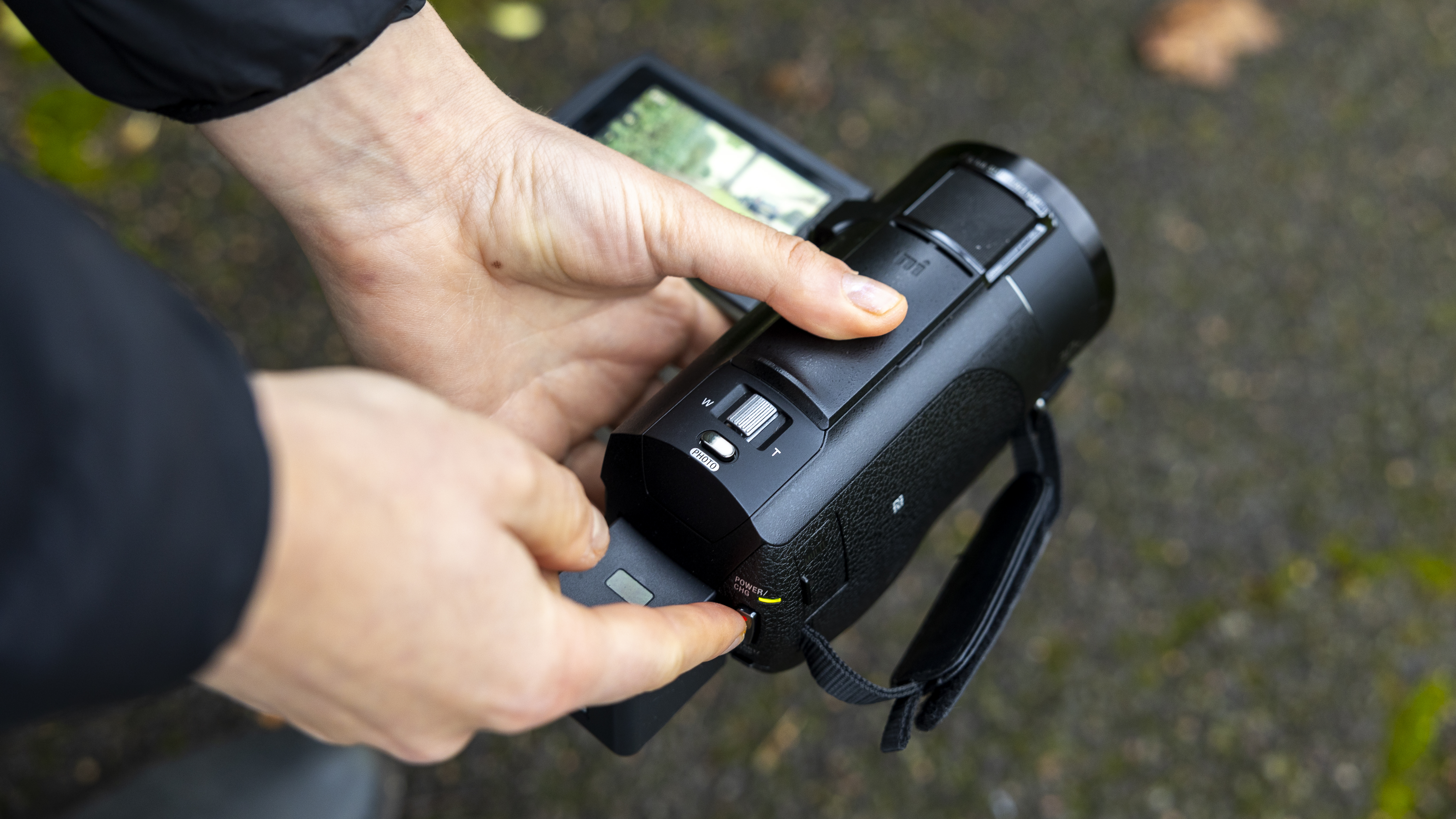 The Sony AX43 camcorder being held close to the ground