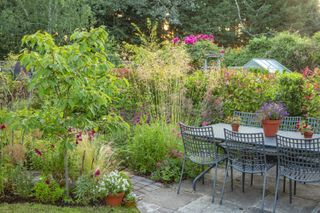 outdoor dining area in cottage garden, surrounded by flowers