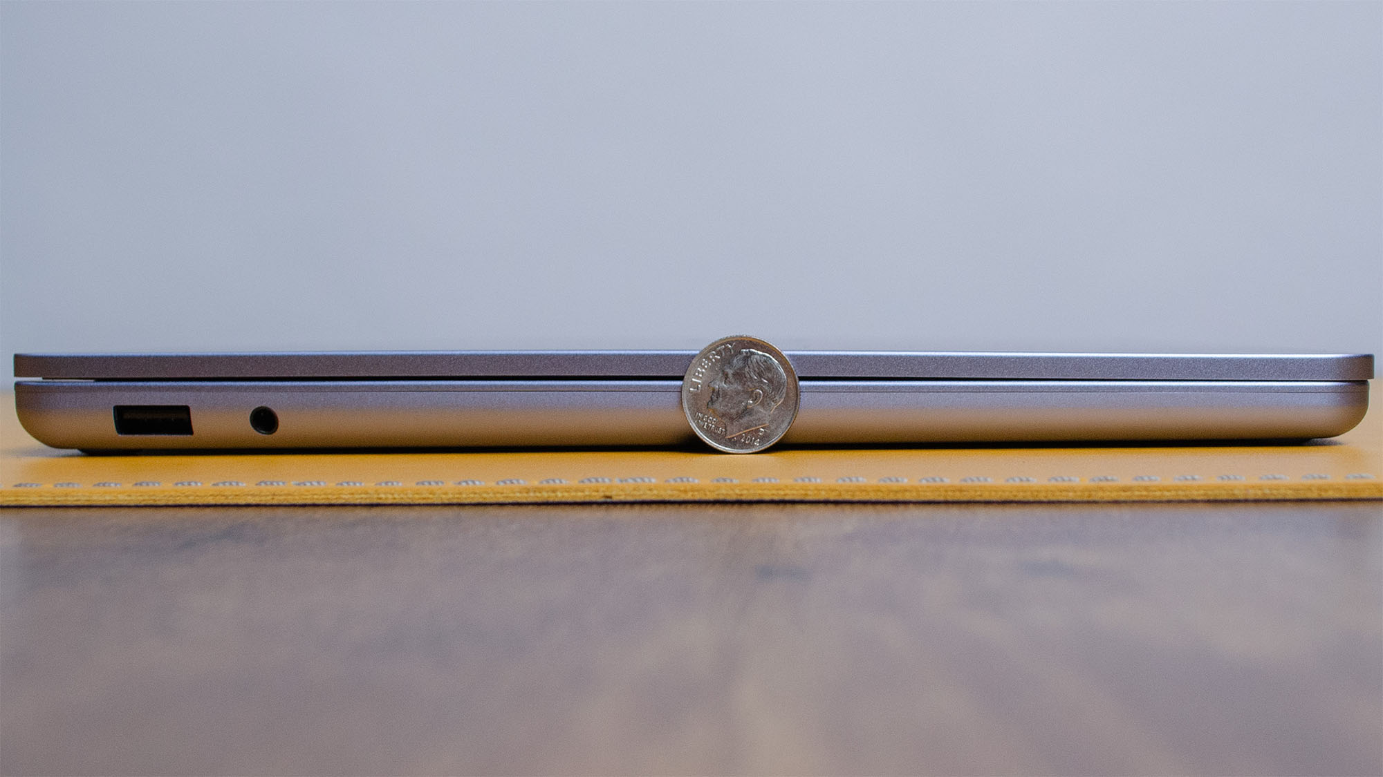 A Microsoft Surface Laptop 13-inch next to a dime to show its thinness