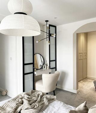 A small vanity space in a bedroom created using Ikea Billy with opaque glass doors and black painted frames