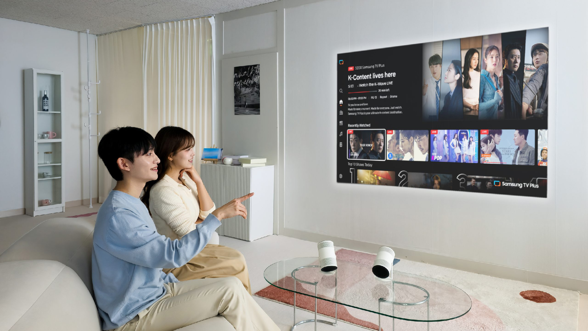 Samsung Freestyle Plus projector on table with screen on