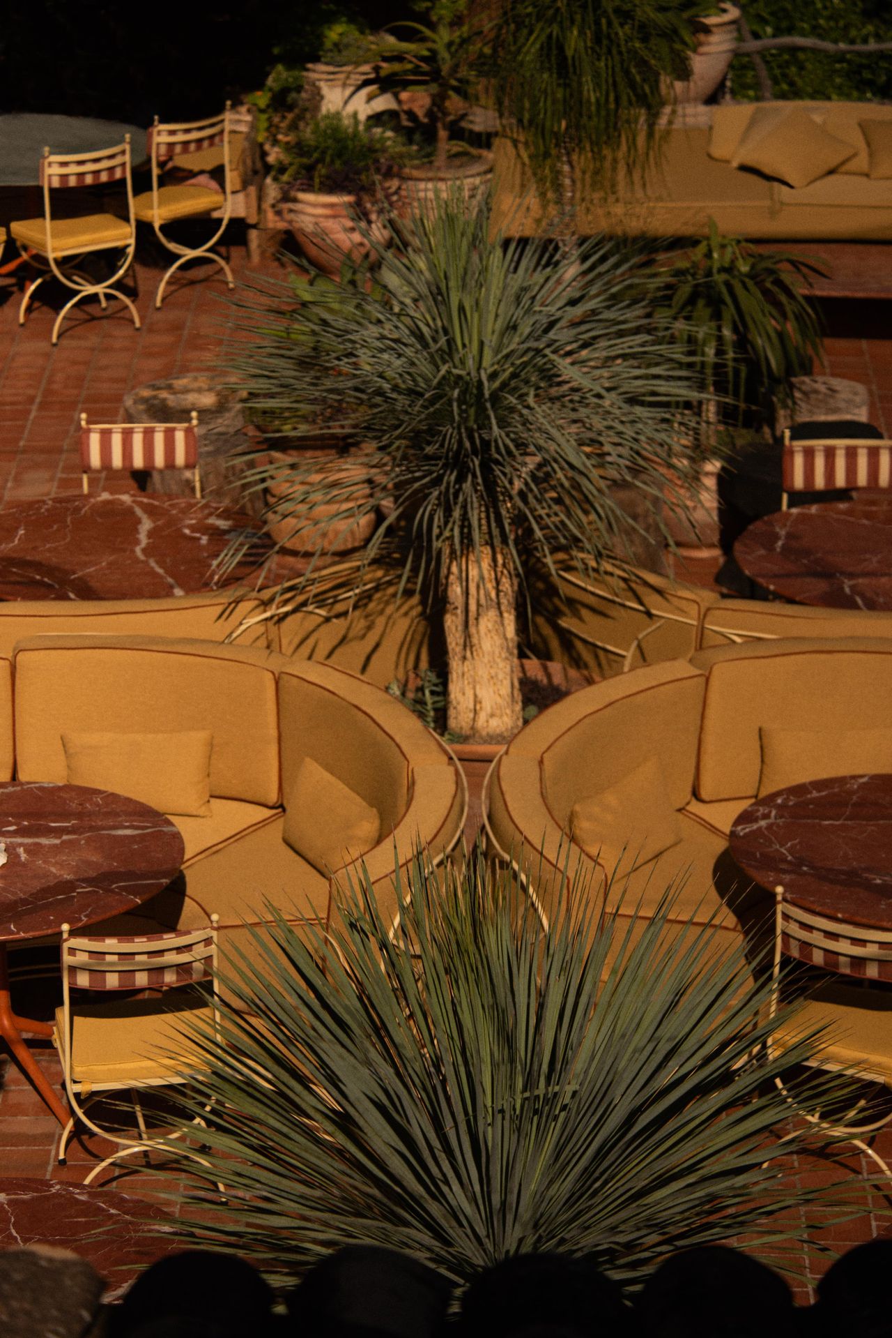 upholstered seating, tables and steel frame chairs on sunny terrace restaurant