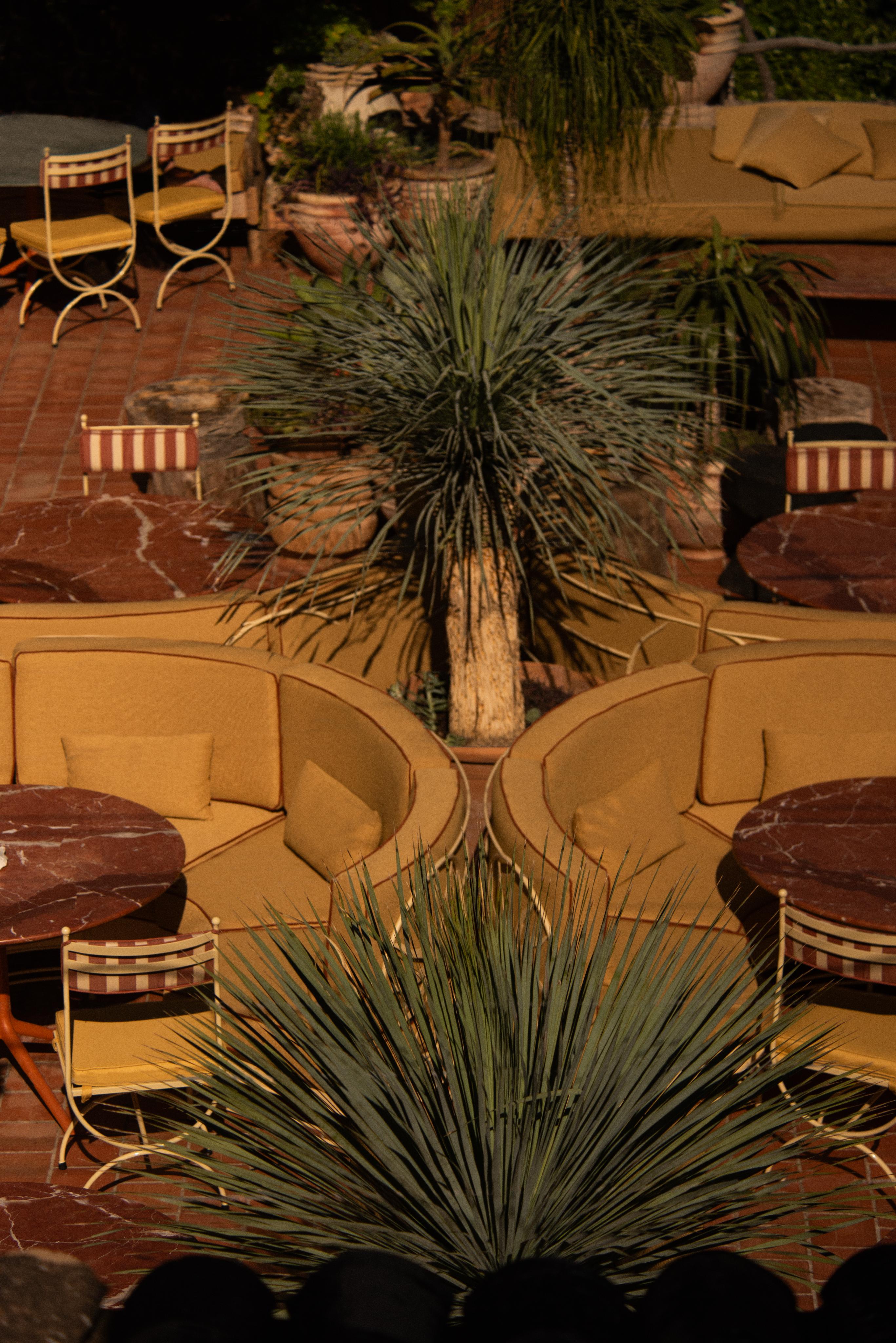 upholstered seating, tables and steel frame chairs on sunny terrace restaurant