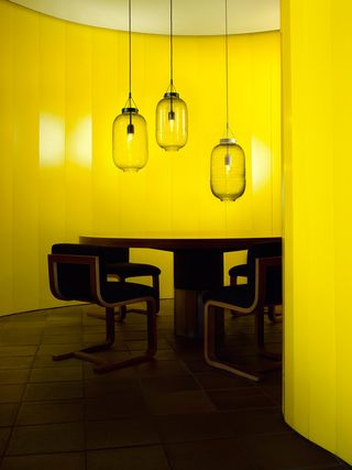 Hanging light bulbs around a table in a yellow room