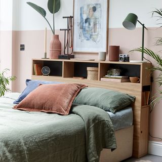 peach colour wall bedroom with green colour bed and caramel blush head board