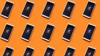 Phones with the TikTok logo against an orange background 