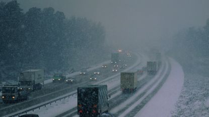 Snow in the UK as traffic drives in Surrey, England